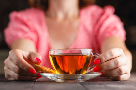 Human hand taking cookie in plate on a tableの写真素材
