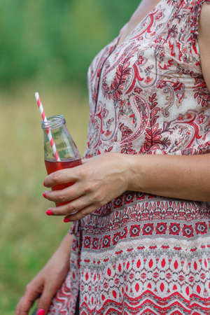 oman is holding tasty smoothie in glass jar with drinking strawの写真素材