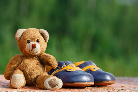Vintage baby shoes with teddy bearの写真素材
