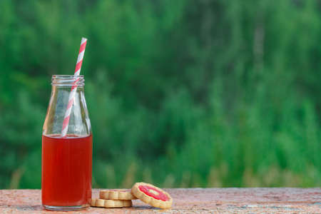 closeup of a red detox drink with a red drinking straw, on a rustic surfaceの写真素材