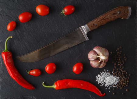 Red tomatoes with rosemary and  olive oil. On black rustic background.の写真素材