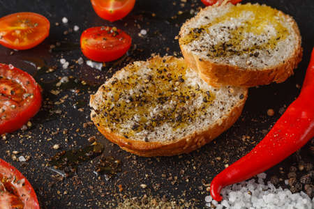 Fresh tomatoes with olive oil and salt. On black rustic background.の写真素材