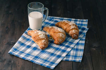 Breakfast with coffee crema, milk, fresh croissants on vintage on wooden backgroundの写真素材