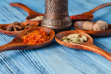 Six spoons full of spices on table in circleの写真素材