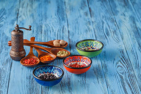 Beautiful colorful spices in spoons on an old wooden blue table. Free space for your textの写真素材