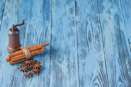 Mill for spices and cinnamon on blue tableの写真素材