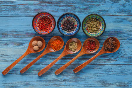 Spices on wooden spoons and in bowlの写真素材