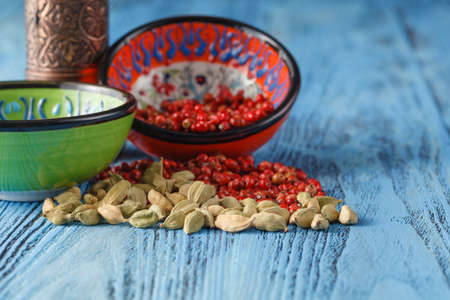 Cardamon and pink pepper on table with millの写真素材