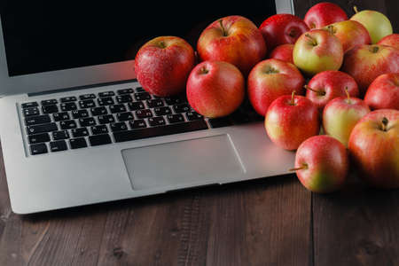 Open Laptop and apples on wooden table. Eco conceptの写真素材