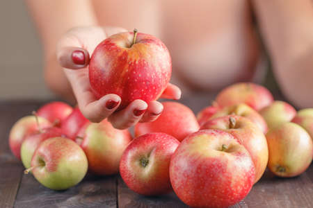 woman offering red apple, shallow DOF, Focus on the appleの写真素材