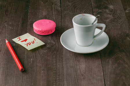 Cup of coffee with lipstick mark and note 'i love you' on table close upの写真素材