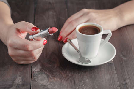 Woman holding hot steaming cup of coffee at homeの写真素材