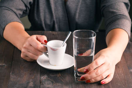 Woman drinking water after espresso coffeeの写真素材
