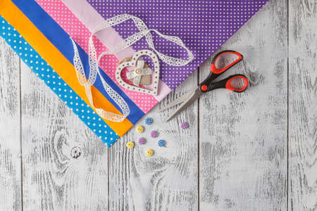 cotton fabrics for sewing, lace and accessories for needlework on wooden background. Set for needlework top viewの写真素材