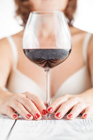 woman tasting wine on bright backgroundの写真素材