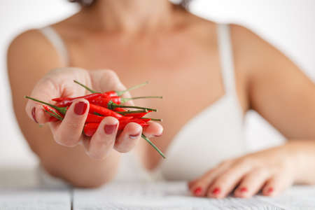 Woman with small red hot peper, selevtive focusの写真素材