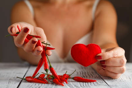 Chili pepper hanging on womans hands