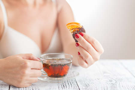 Woman drink tea at bedroom with sweets
