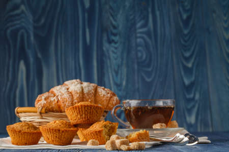 Breakfast with herbal tea and croissant on wooden vintage tableの写真素材