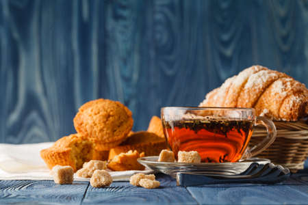 Breakfast with herbal tea and croissant on wooden vintage tableの写真素材