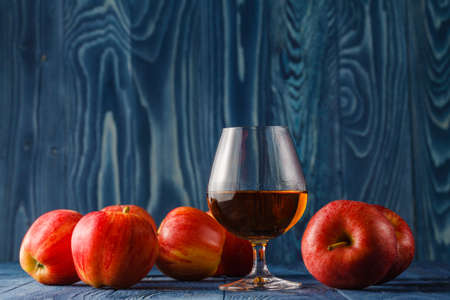 glass of Calvados Brandy and red applesの写真素材