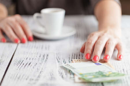 woman ready to pay empty finished cappuccino coffee cupの写真素材