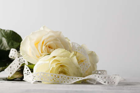 white fresh rose flowers on white lace backgroundの写真素材