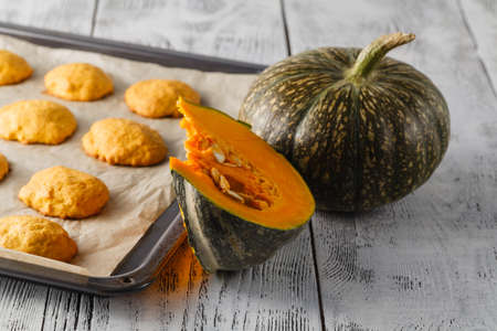 Pumpkin cookies on wooden table with pumpkins on a background, selective focus