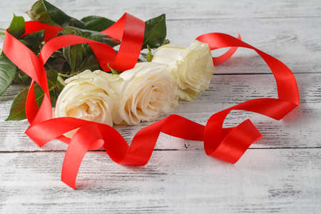 Roses and a ribbons on wooden board, Valentines Day background, wedding dayの写真素材