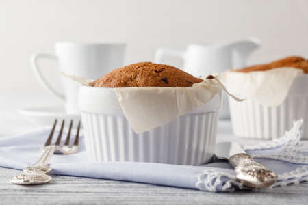 Cappuccino coffee cup with muffin on white tableの写真素材