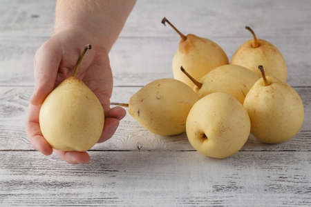 Hand with pears on wood table closeupの写真素材