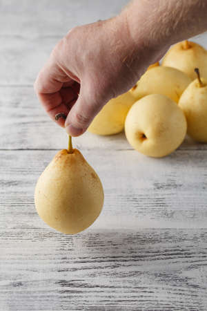 Hand with Pears on wooden tableの写真素材