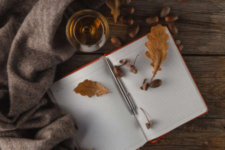 Autumn maple leaves and woolen scarf on a wooden background.の写真素材