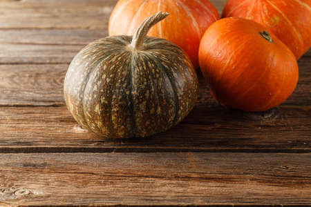 Pumpkin with autumn leaves on wooden table