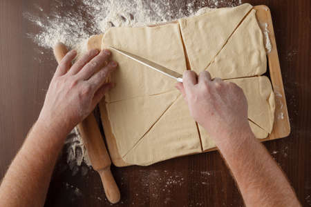 Making dough by mens hands on wooden table backgroundの写真素材