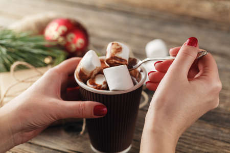 cup with cocoa and marshmallow in the hands of the girl. Manicure gel nail.の写真素材