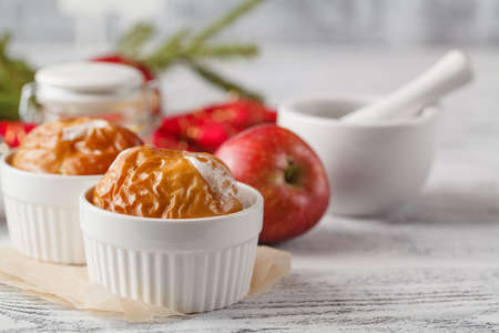 Christmas background of homemade oven baked apples, spices, nuts, cons and decorations on wooden table with copy-spaceの写真素材