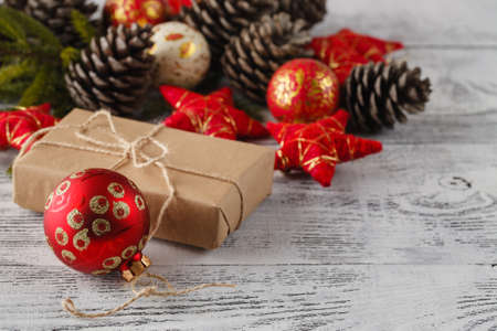 christmas gift with red balls bow on white wooden backgroundの写真素材