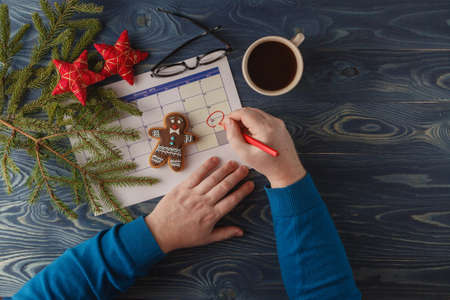 Hand  mark Christmas date on a calendar