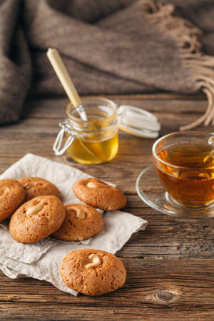 Cup of tea with oatmeal cookie on dark wooden table covert tableclothの写真素材