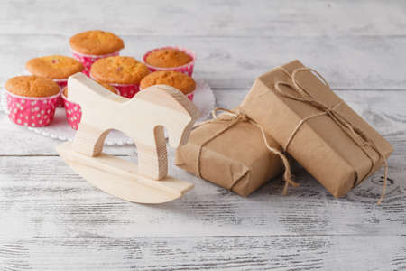Aromatic Homemade Lemon Muffins with toy horse and giftbox on the gray backgroundの写真素材