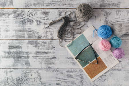 Knitting needles and yarn on wooden background/natural wool knitting backgroundの写真素材