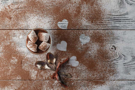 Traditional Italian dessert tiramisu decorated with cocoa. On a white table the heart of the cocoaの写真素材