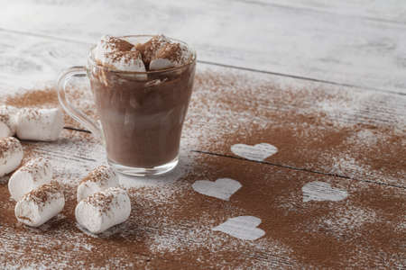 figure drawings in the shape of a heart on the cocoa powder scattered on a white backgroundの写真素材