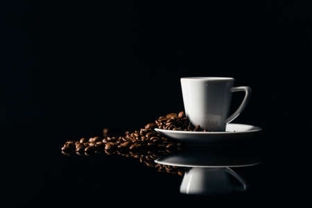 Small cup of black coffee on a dark background with coffee beansの写真素材