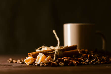 Coffee cup with burlap sack of roasted beans on rustic table