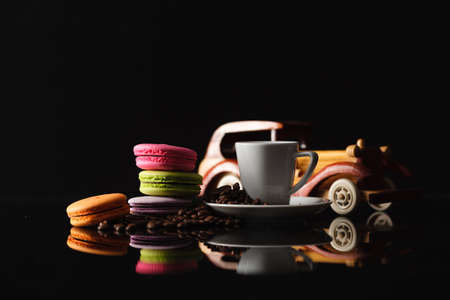 Sweet and colorful french macaroon (macaron) with coffee  with reflection on mirror table