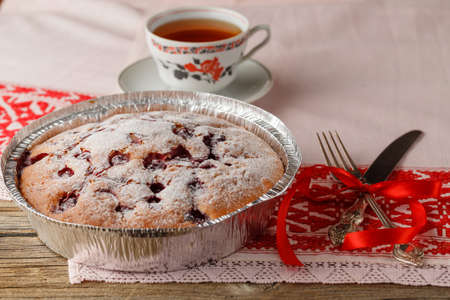 Clafoutis cherry pie on rustic wooden background