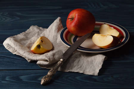 Red apples with slices over blue wooden backgroundの写真素材