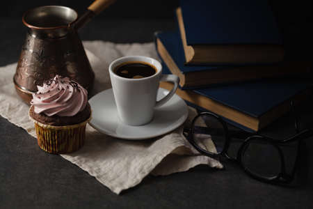 Chocolate cupcakes and coffee on dark background. Photo in a dark styleの写真素材